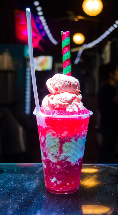 A cup filled with red and white shaved ice.