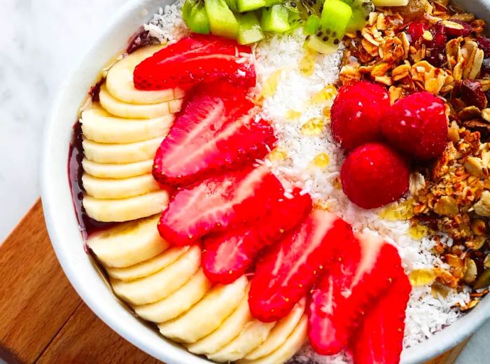 A bowl filled with beautifully layered slices of fruit.