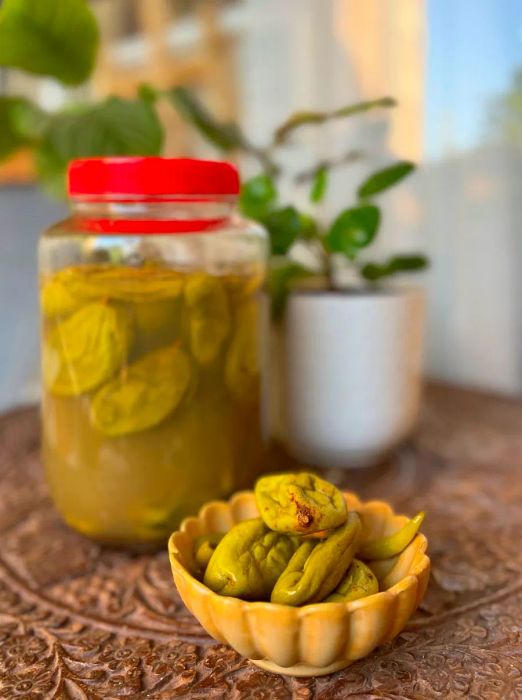 A bowl of pickled green mangoes alongside the jar they came from.