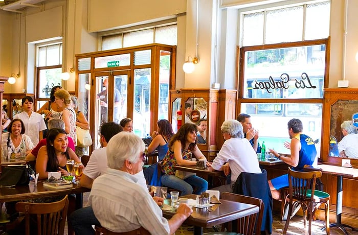 Diners enjoying their meals at wooden tables in a bright, airy cafe