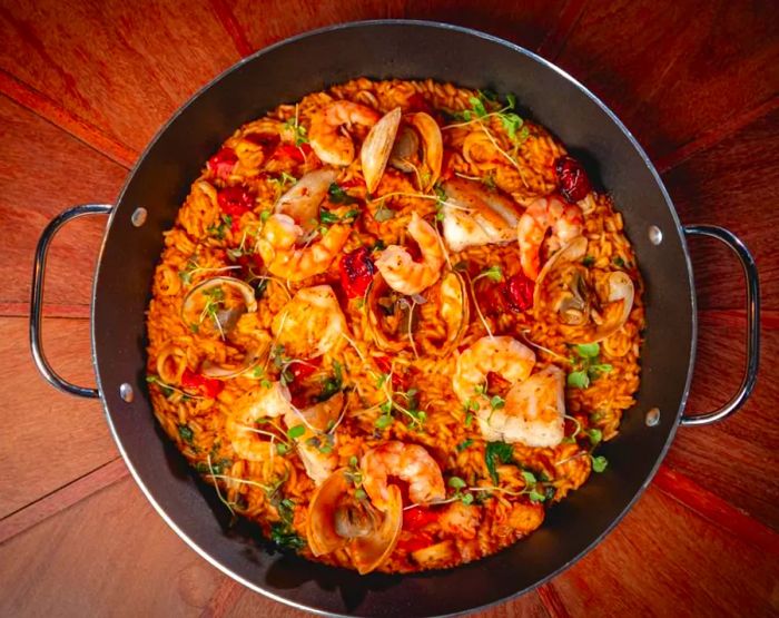 An overhead view of a pan filled with seafood-rich rice, featuring shrimp and mussels.