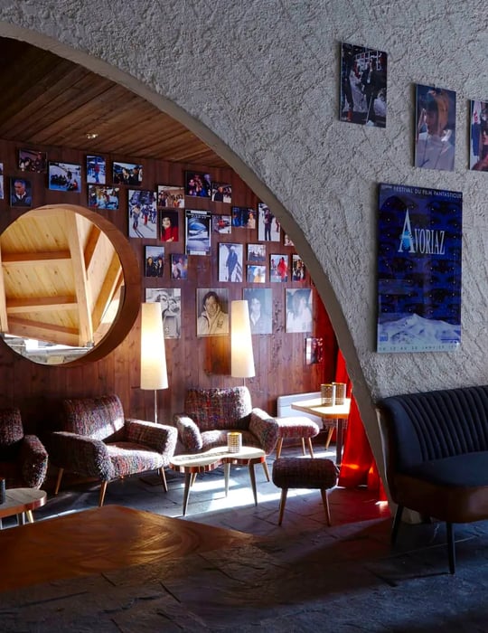 A cozy seating area adorned with fur-covered chairs, quirky archways, and vintage photographs.