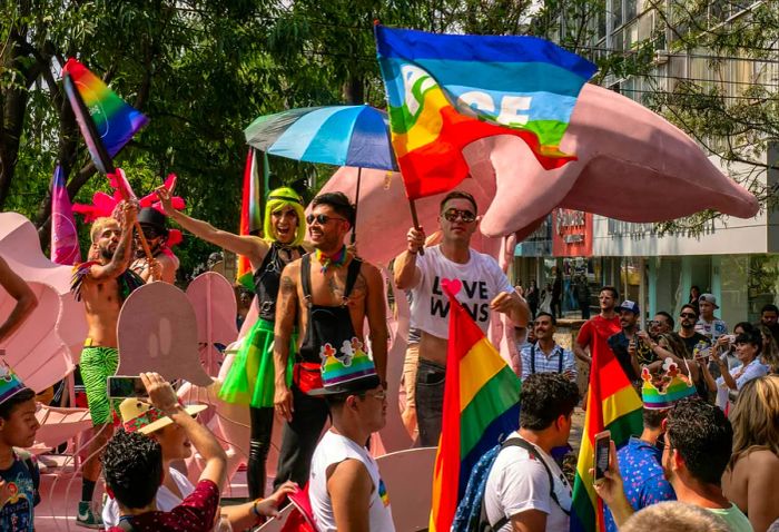 A float filled with people celebrating and waving rainbow flags during the Pride Parade in Guadalajara, Jalisco, Mexico