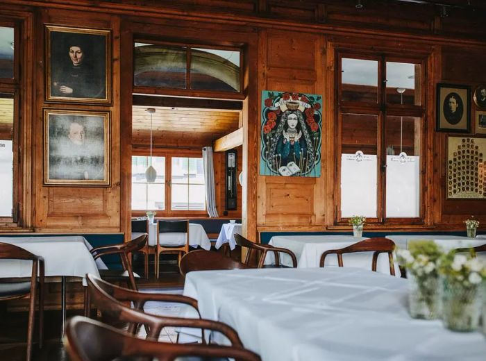 A restaurant interior featuring wood paneling and adorned with various portraits.