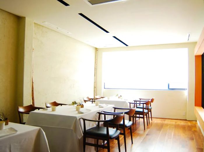 A bright dining area featuring tables prepared for lunch.