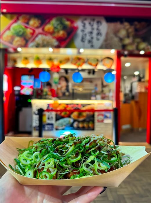 A serving of takoyaki generously topped with various garnishes.