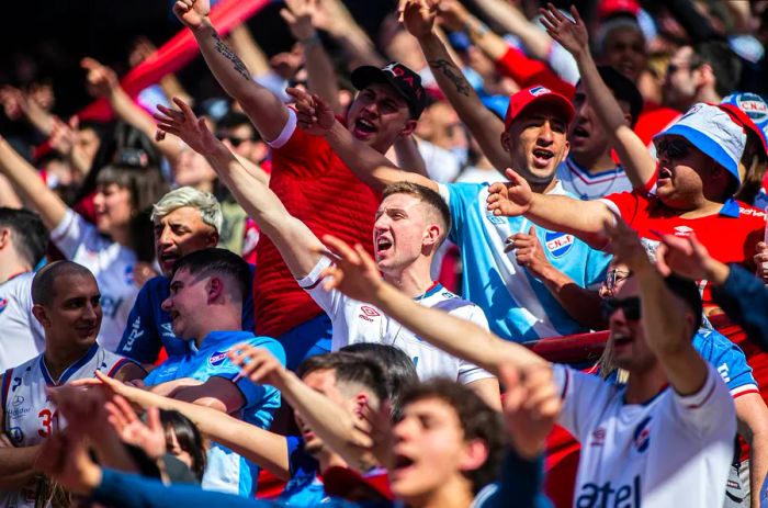 Supporters of Nacional cheer enthusiastically in the stands at Gran Parque Central stadium, Montevideo, Uruguay, South America.