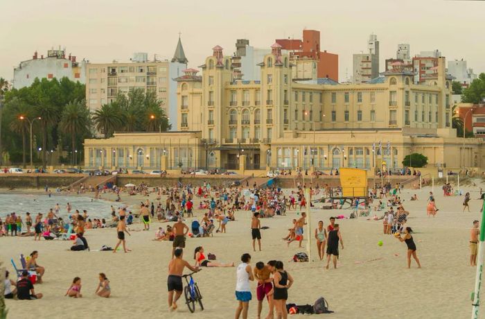 A stunning sunset at Ramyres beach, with sunbathers enjoying a summer day in Montevideo, Uruguay.