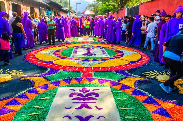 Spectators and float bearers admire the colorful sawdust designs that fill the streets of Antigua, Guatemala, during Semana Santa.