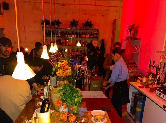 A view of a bustling bar, with a vibrant display of plants and flowers covering the counter.