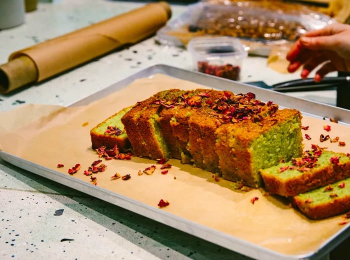 A beautifully sliced loaf cake adorned with pistachios.