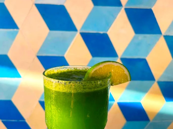 A vibrant green cocktail adorned with a lime slice.