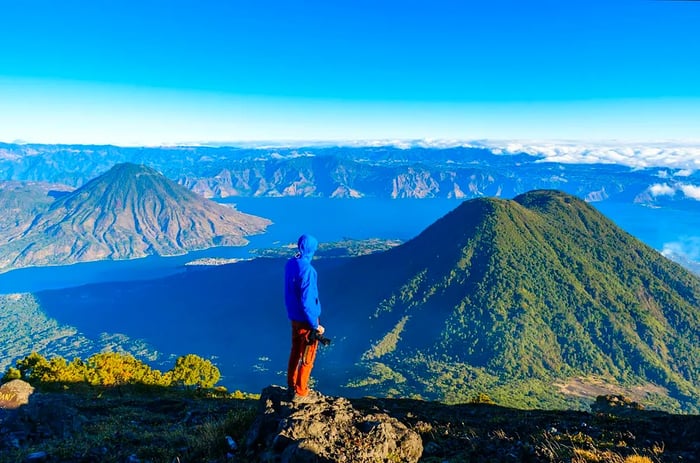 A hiker gazing over the volcanic peaks surrounding Lake Atitlán