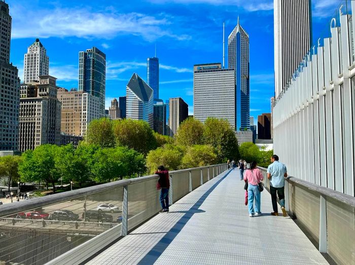 A group of people strolls along the elevated Nichols Bridgeway, linking the Art Institute of Chicago to Millennium Park.