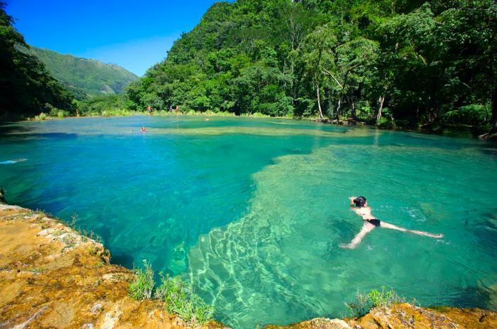 Visitors swimming in the stunning turquoise waters of Semuc Champey