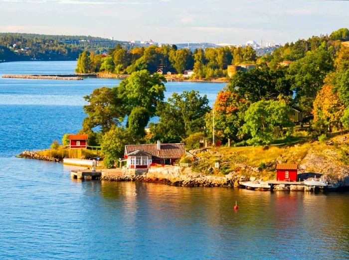 Quaint cabins line the rugged shore of an island in the Stockholm Archipelago, Baltic Sea, Sweden.