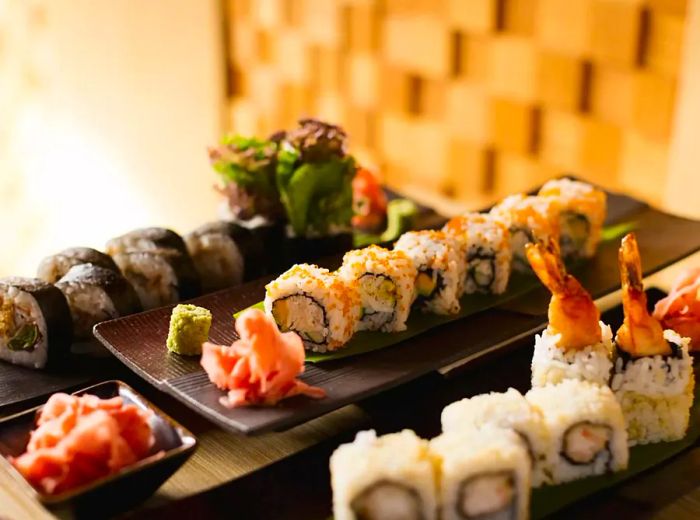 A selection of sushi rolls elegantly arranged on long platters.