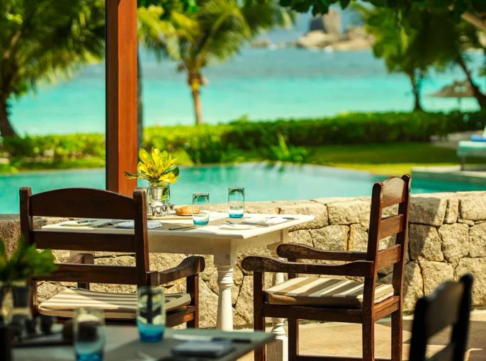 A beautifully set lunch table by the pool, with the ocean view beyond.