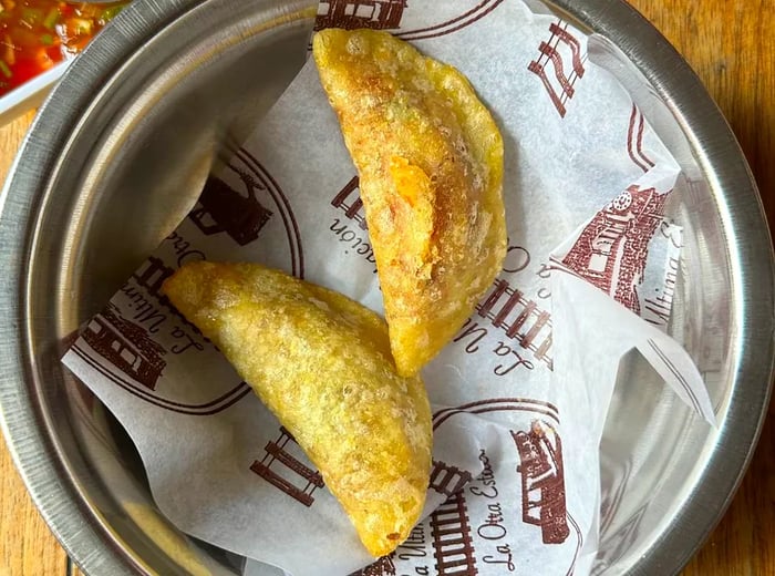 Aerial view of two empanadas placed in a metal dish.