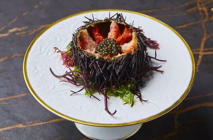 A beautifully presented dish of sea urchin, shrimp, and caviar served in an urchin shell.