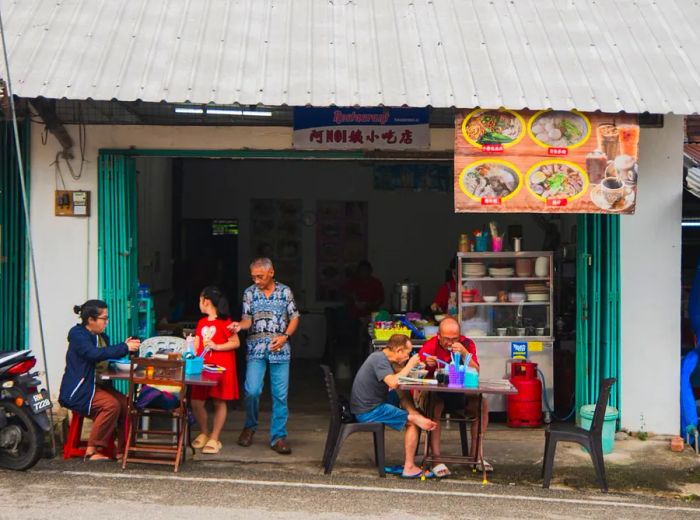 Patrons dining at outdoor tables in front of a cozy restaurant.