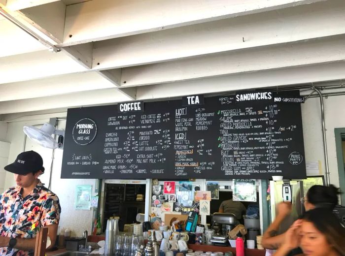 The cafe features a counter adorned with a handwritten chalkboard menu overhead.