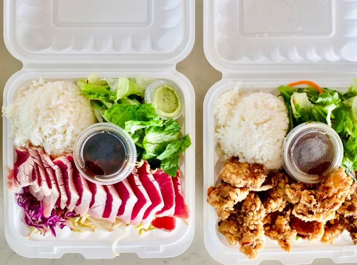 Two takeout containers: one filled with fried chicken and the other with sashimi slices, accompanied by greens and rice.