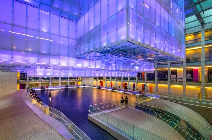 Interior of the Kirchner Cultural Centre (Centro Cultural Kirchner or CCK) in Buenos Aires, Argentina, bathed in purple light.