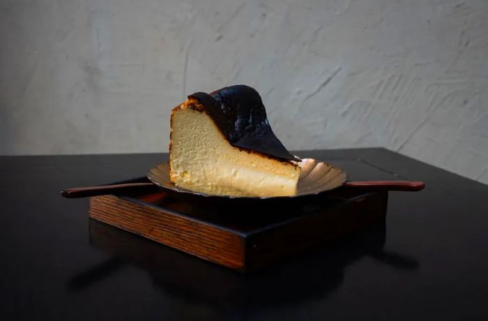 A tall slice of Basque cheesecake with a caramelized top.