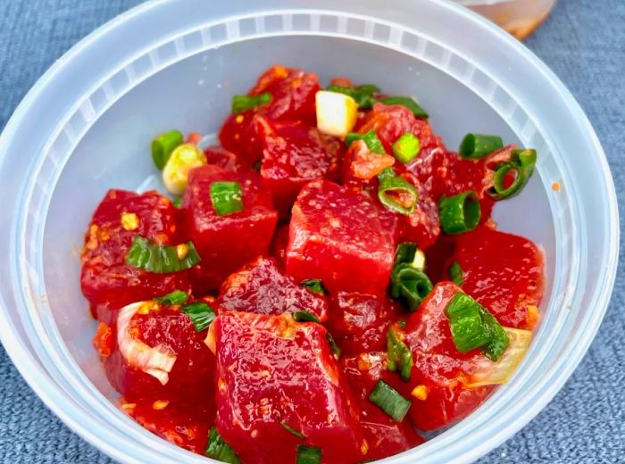 A takeout container filled with cubed tuna poke.