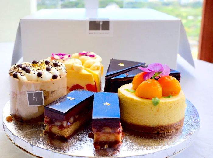 A beautifully arranged pastry box filled with an assortment of cakes.