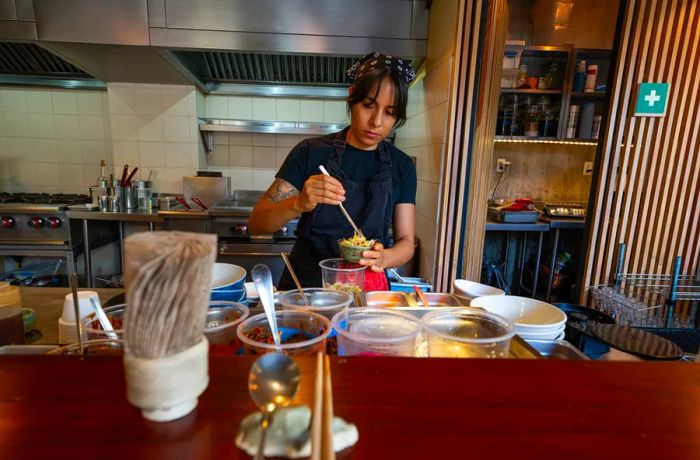 A chef skillfully uses chopsticks to prepare ingredients.