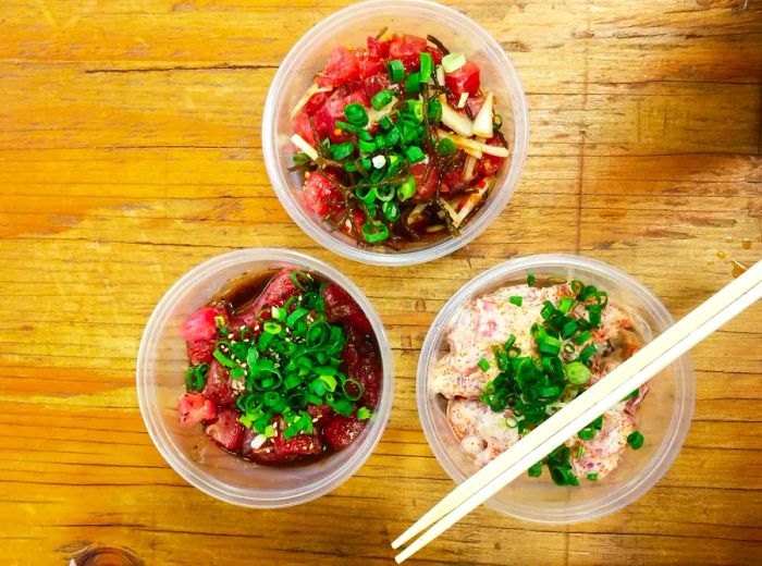 Takeout containers filled with fresh poke and chopsticks ready to go.