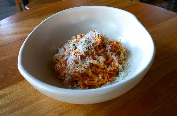 A heap of noodles garnished with shredded cheese.