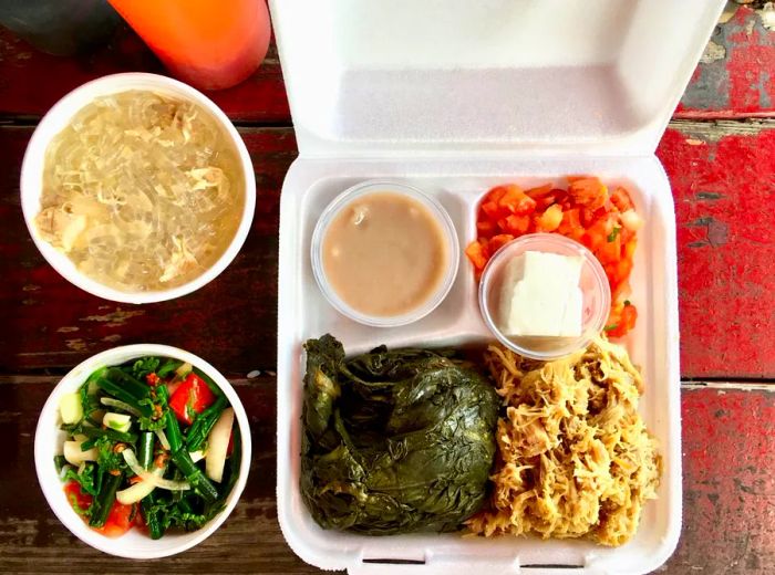 A takeout container filled with a variety of dishes.