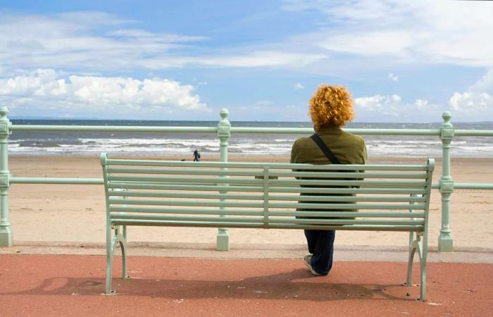 A woman relaxes on a beach along the Edinburgh coastline.