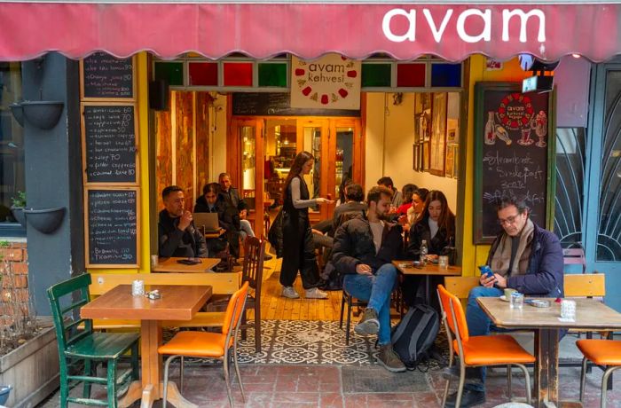 Patrons enjoying their time at tables inside and outside a bustling café.