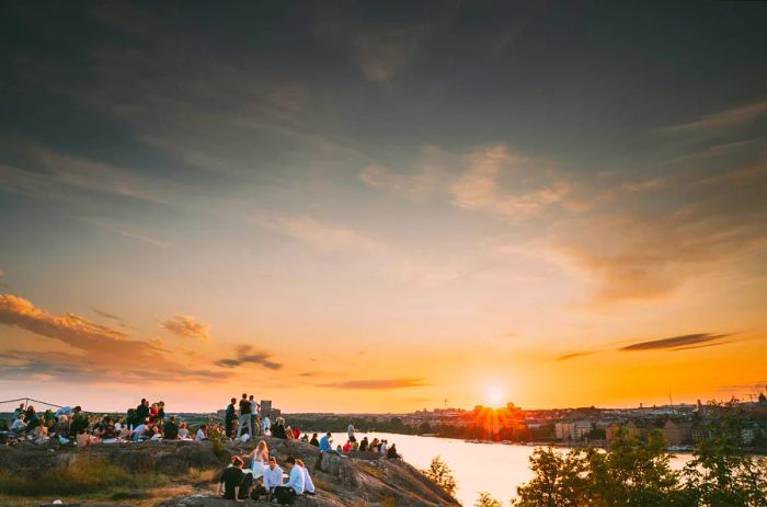 Young people enjoying a summer sunset at Skinnarviksberget, a popular gathering spot.