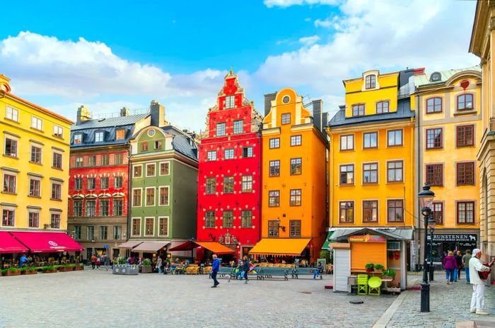 Charming, vibrant buildings with shops and sidewalk cafés at Stortorget, a public square in Gamla Stan, Stockholm's medieval old town.