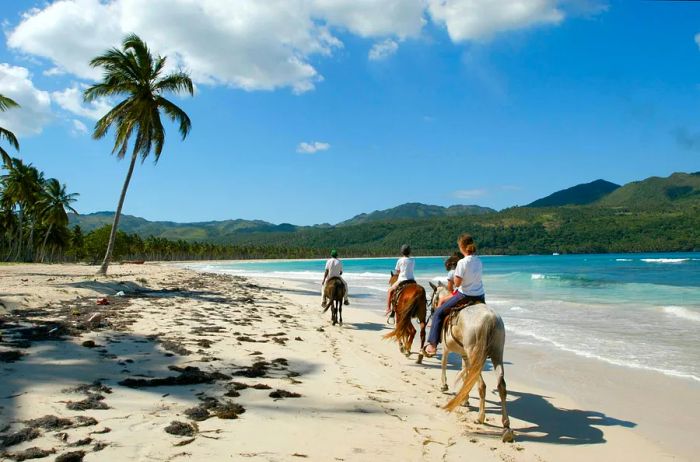 Riders on horseback along the beach at Rincon near Las Galeras in the Dominican Republic.