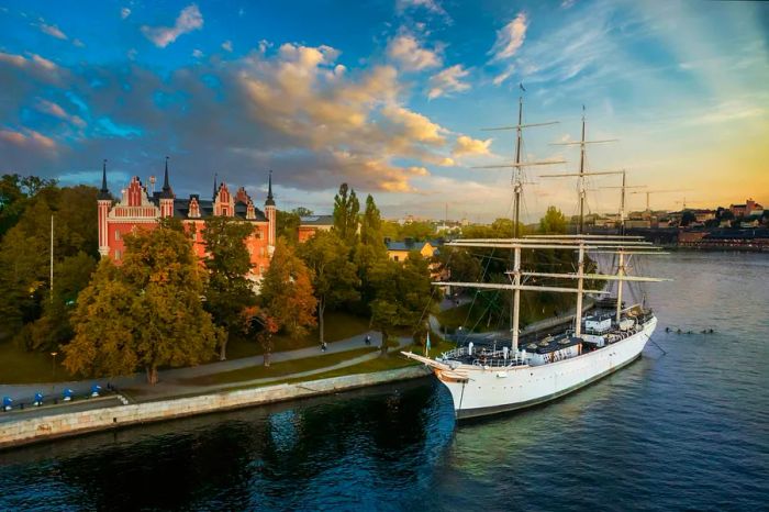 The fully-rigged sailing ship af Chapman docked on the quay of Skeppsholmen, captured at sunset in Stockholm.