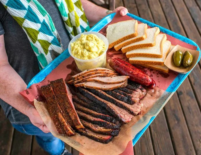 A platter featuring pork ribs, smoked turkey, sausage, and brisket from Franklin BBQ in Austin.