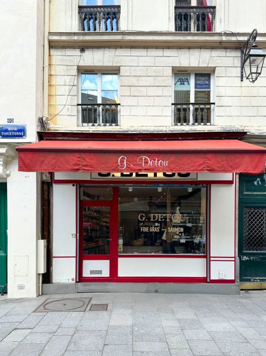 A charming Parisian storefront with an awning and glass display.