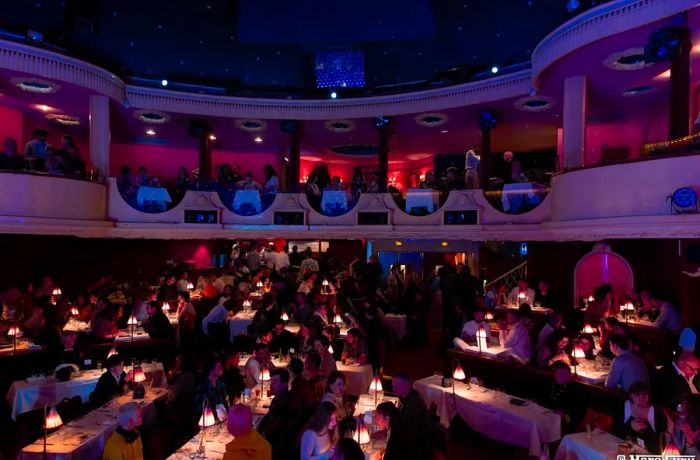 Patrons seated at tables in a dimly lit setting.