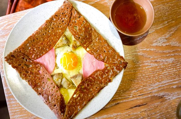 A galette stuffed with a fried egg and meat.