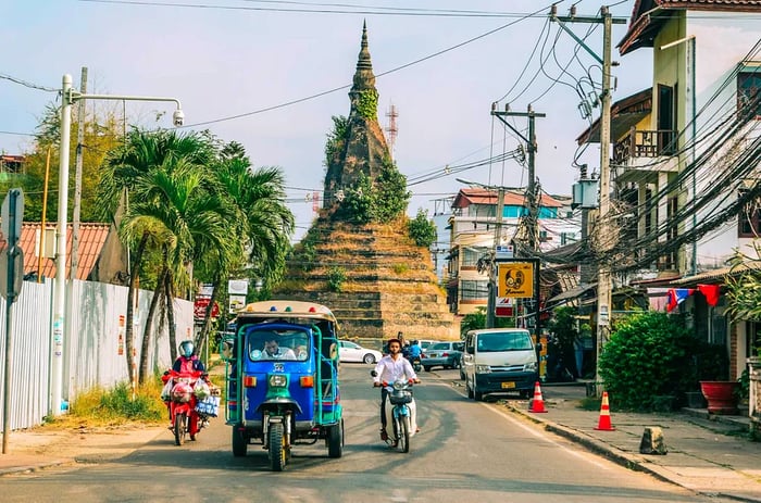 A tuk-tuk taxi navigates a street in Vientiane, Laos.