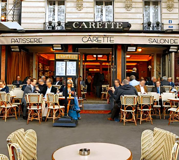 Patrons enjoy their time seated at tables outside a café.