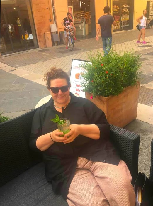 Food critic Katy McGuinness enjoying a cocktail while seated on a bench