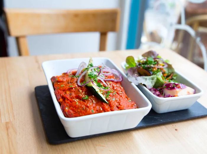 A plate of lasagna accompanied by a fresh salad.