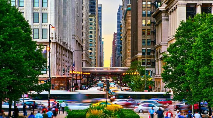 Pedestrians navigate the bustling streets of Chicago as buses and the L zip by, captured in a blur of motion.